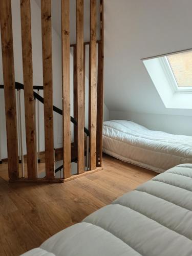 une chambre avec deux lits et une fenêtre dans l'établissement Maison centre de sainte mère église, à Sainte-Mère-Église