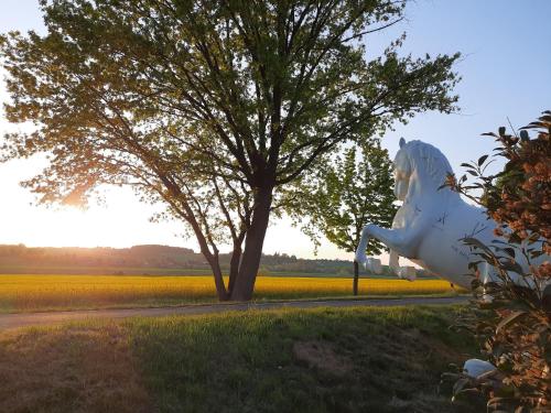 a white horse statue in front of a tree at Reiterhof Schmidt, Gaststätte & Pension in Golk