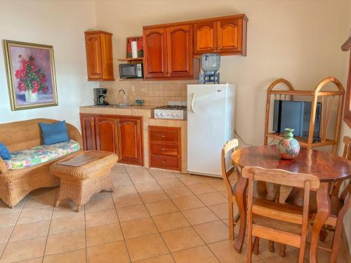 a kitchen with a table and a white refrigerator at Seville Suite in San Juan del Sur