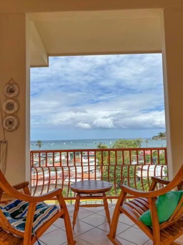 a room with a view of the ocean from a balcony at Seville Suite in San Juan del Sur
