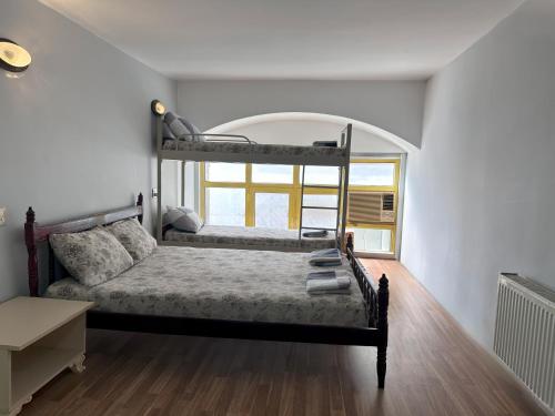 two bunk beds in a room with a window at Flora Music & Art Hostel in Baku