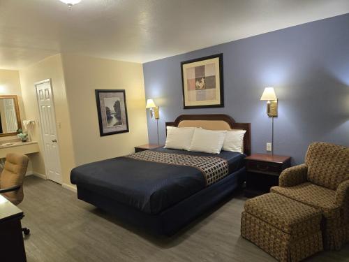 a hotel room with a bed and a chair at Rodeway Inn & Suites Blythe I-10 in Blythe