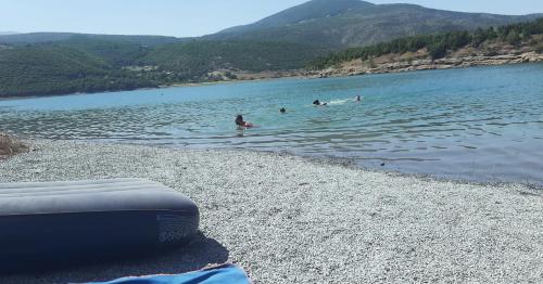 a group of people swimming in a body of water at Camping SuperPanorama in Kukës