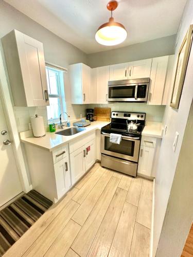 a kitchen with white cabinets and a stove top oven at Las Olas 1BR Pool Free Parking Walk to Beach & Restaurants in Fort Lauderdale