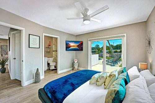 Un dormitorio con una cama grande y un ventilador de techo. en NEW Waterfront Tropic Oasis - Heated Pool, Canal, Dock, Air Hockey, en Boynton Beach