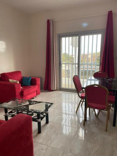 a living room with a red couch and a table at Residence Saint James in Somone