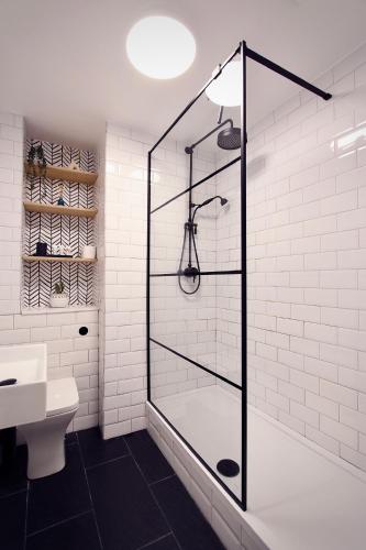 a shower with a glass door in a bathroom at Spacious Two Bedroom Apartment in the Heart of Notting Hill in London