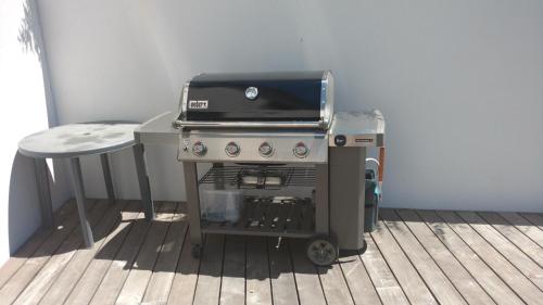 un gril assis à côté d'une table avec une chaise dans l'établissement Maison moderne avec piscine, à Alès