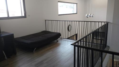 - un canapé noir dans une pièce avec un escalier dans l'établissement Maison moderne avec piscine, à Alès