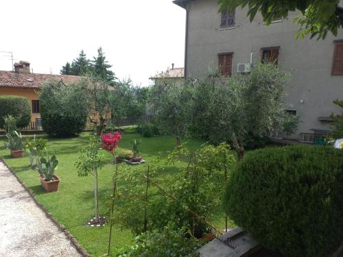 a garden with trees and bushes and a building at Giardino Fiorito in Toscolano Maderno