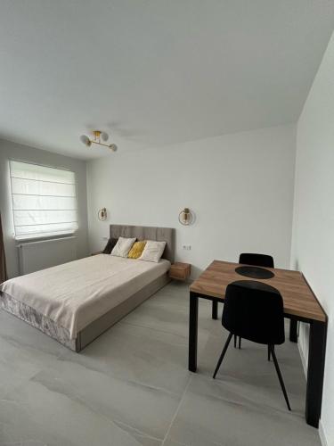 a bedroom with a bed and a desk and a table at Kima Apartament Pijarska in Katowice