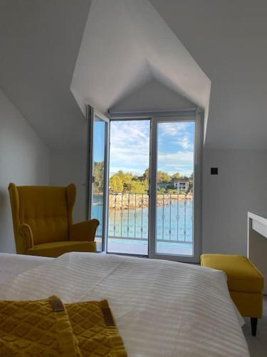 a bedroom with a bed and a chair and a window at La Familia in Blato
