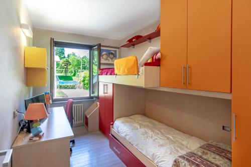 ein Schlafsaal mit einem Bett, einem Schreibtisch und Schränken in der Unterkunft VILLA NOVELLI con Piscina e ampio Giardino in Castelletto sopra Ticino