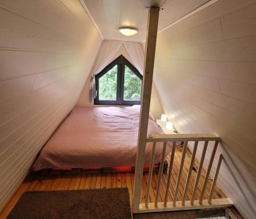 佐洛卡罗斯ApróLak Apartman Zalakaros的窗户的小房子里的一张床位