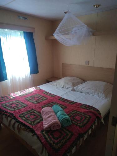 une chambre avec un lit avec deux serviettes dessus dans l'établissement Mobile home style créole, à Graveson
