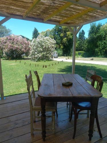 une table et des chaises en bois assises sur une terrasse couverte dans l'établissement Mobile home style créole, à Graveson