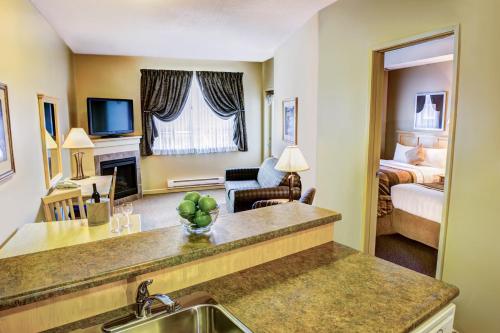 a hotel room with a kitchen and a bedroom at Clearwater Hotel Ltd in Fort McMurray