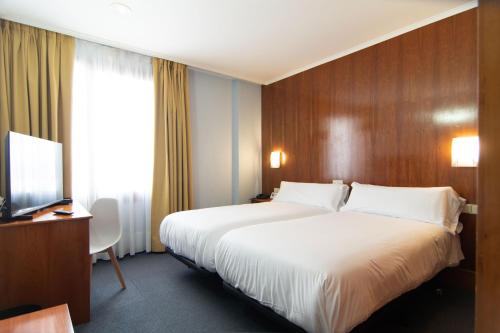 a hotel room with a large bed and a desk at Hotel Beratxa in Tafalla