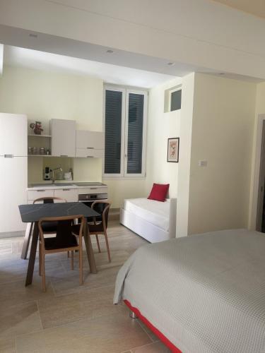 a bedroom with a bed and a table and a kitchen at Palazzo Lanzilao's Rooms in Lecce