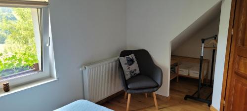 a black chair in a room with a window at O'Sowa Noclegi Wetlina in Wetlina