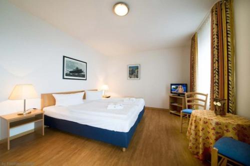 a hotel room with a large bed and a table at Haus Volksbank by Rujana in Binz