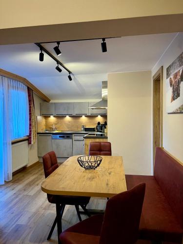 a living room with a table and a kitchen at apart STURPEN in Sankt Leonhard im Pitztal