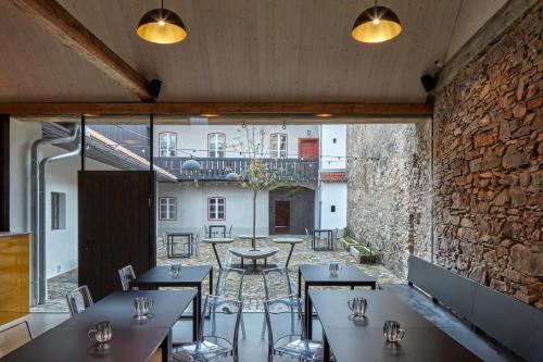 a restaurant with tables and chairs and a stone wall at Just Jimramov in Jimramov