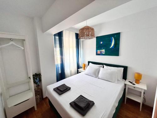 a bedroom with a white bed and a window at Sea Breeze III Apartment in Perea