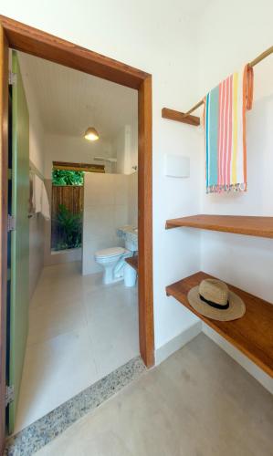 a bathroom with a toilet and a sink at Jardim Cumuru - Suítes in Cumuruxatiba