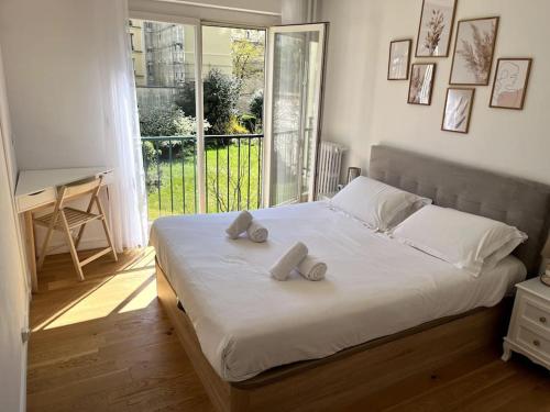 une chambre avec un lit avec deux oreillers dessus dans l'établissement Superbe appartement avec belle vue jardin, à Paris