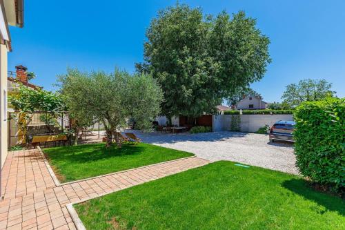 a backyard with a lawn and a tree at Nino with Shared Pool in Poreč