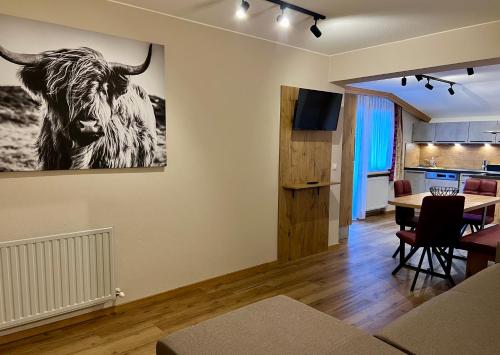 a living room with a picture of a cow on the wall at apart STURPEN in Sankt Leonhard im Pitztal