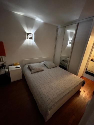 - une chambre avec un lit et deux lumières sur le mur dans l'établissement Appartement meublé très bien situé, à Boulogne-Billancourt