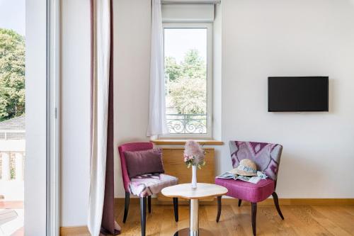 a living room with two chairs and a table at Villa Elisa M in Aubenas