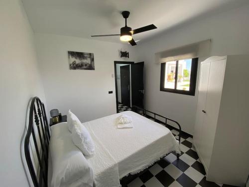 a bedroom with a bed and a ceiling fan at Villa con piscina Camino Doñana in Sanlúcar de Barrameda