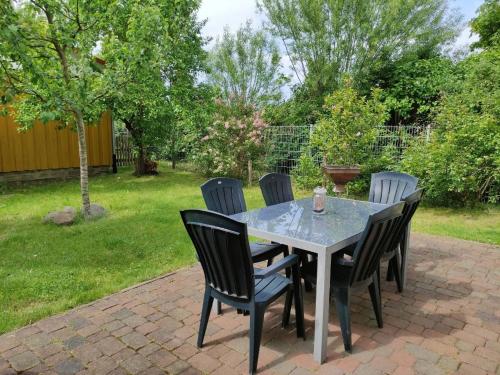 a table and chairs on a brick patio at Bungalow mit Terrasse und Spielplatz in Ostseenähe in Wobbelkow