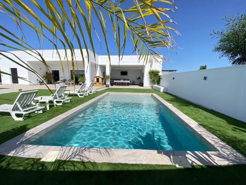 a swimming pool in the backyard of a house at Villa con piscina Camino Doñana in Sanlúcar de Barrameda