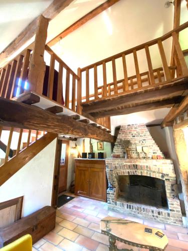 - un salon avec une cheminée en pierre et des escaliers en bois dans l'établissement Le Manoir de la Lanterne et son cottage - 2 à 9 pers, à Neuville-sur-Touques