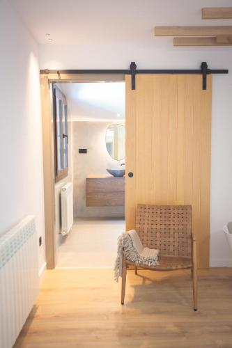 a door to a bathroom with a bench in a room at L'indret del Pedraforca Adults Only in Saldés
