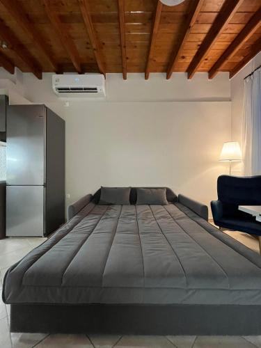 a bedroom with a large bed and a chair at Aegean Dream Residence in Plomari