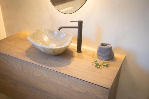 a bowl sink on a wooden counter with a mirror at L'indret del Pedraforca Adults Only in Saldés