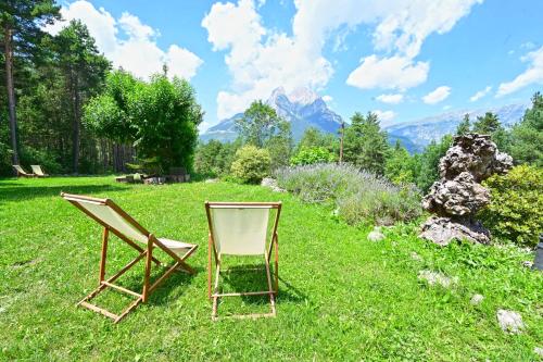 two chairs sitting in the grass in a field at L'indret del Pedraforca Adults Only in Saldés