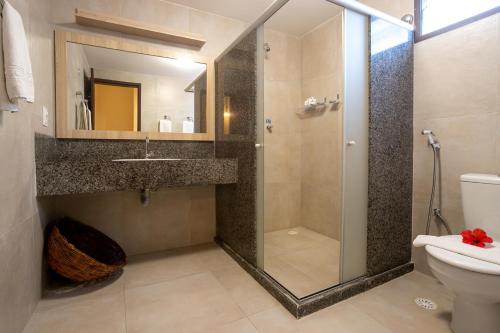 a bathroom with a shower and a sink and a toilet at Pousada Tabapitanga in Porto De Galinhas