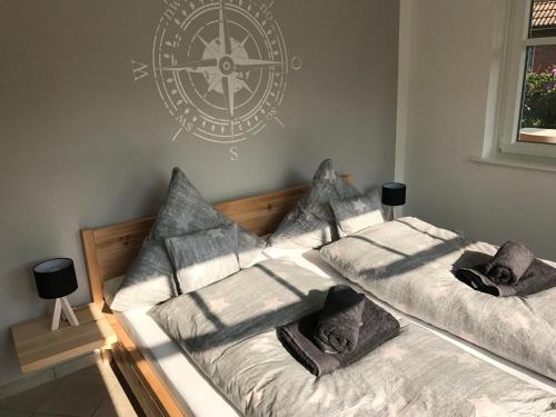 two beds in a room with a clock on the wall at "Tag am Meer" - Residenz Glücksmomente EG in Langeoog