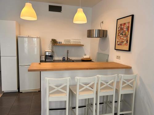 une cuisine avec un comptoir avec trois tabourets dans l'établissement Appartement 6 personnes place de la joliette, à Marseille