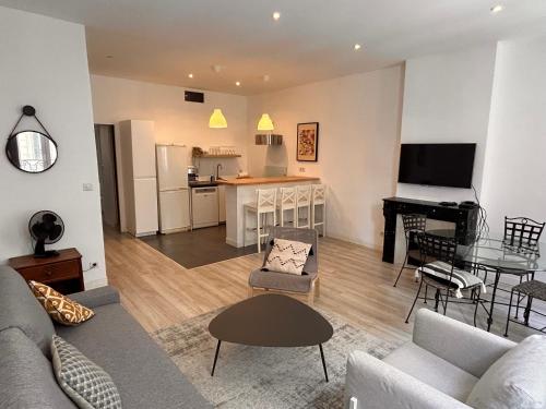 - un salon avec un canapé, une table et un piano dans l'établissement Appartement 6 personnes place de la joliette, à Marseille