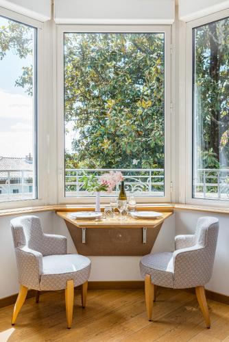 a room with two chairs and a table and two windows at Villa Elisa M in Aubenas