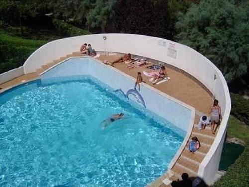 une vue aérienne d'une piscine avec des gens dedans dans l'établissement Vittoria Immobilier 12 -REGLEMENT SUR PLACE - chèques vacances acceptés, à La Grande Motte