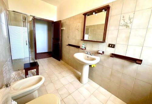 a bathroom with a sink and a toilet and a mirror at Villa Rina in Avola