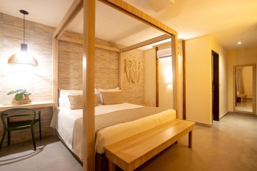 a bedroom with a large bed and a table at Pousada Tabapitanga in Porto De Galinhas